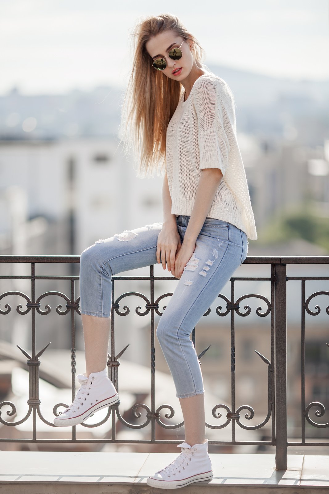 Fashion model. Summer look. Jeans, sneakers, sweater.